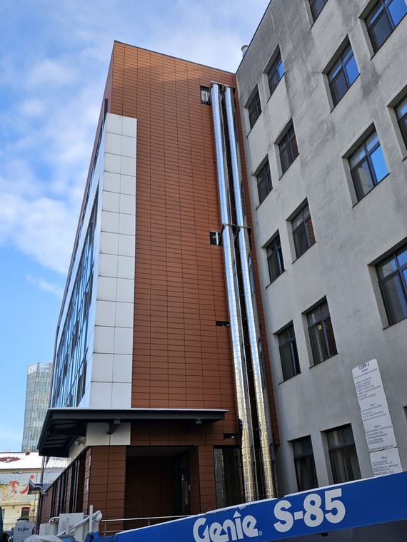 Traseu vertical de coș de fum din inox pe fațada unei clădiri de spital