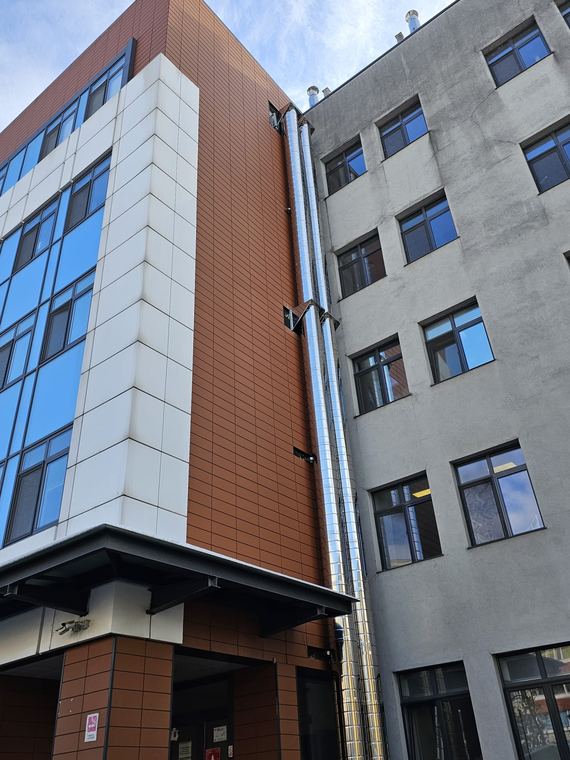 Fațada clădirii cu traseul coșului de fum industrial montat pe colț