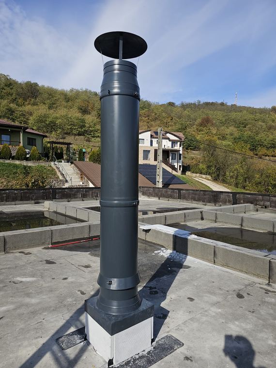 Coș de fum din inox montat pe acoperișul plat al unei locuințe