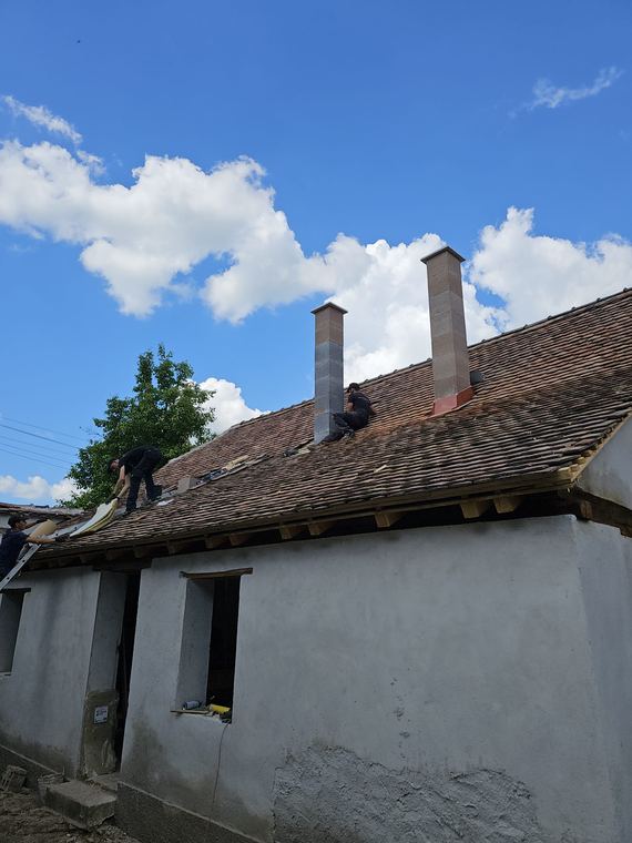 Verificarea coșurilor de fum pe acoperișul unei case vechi